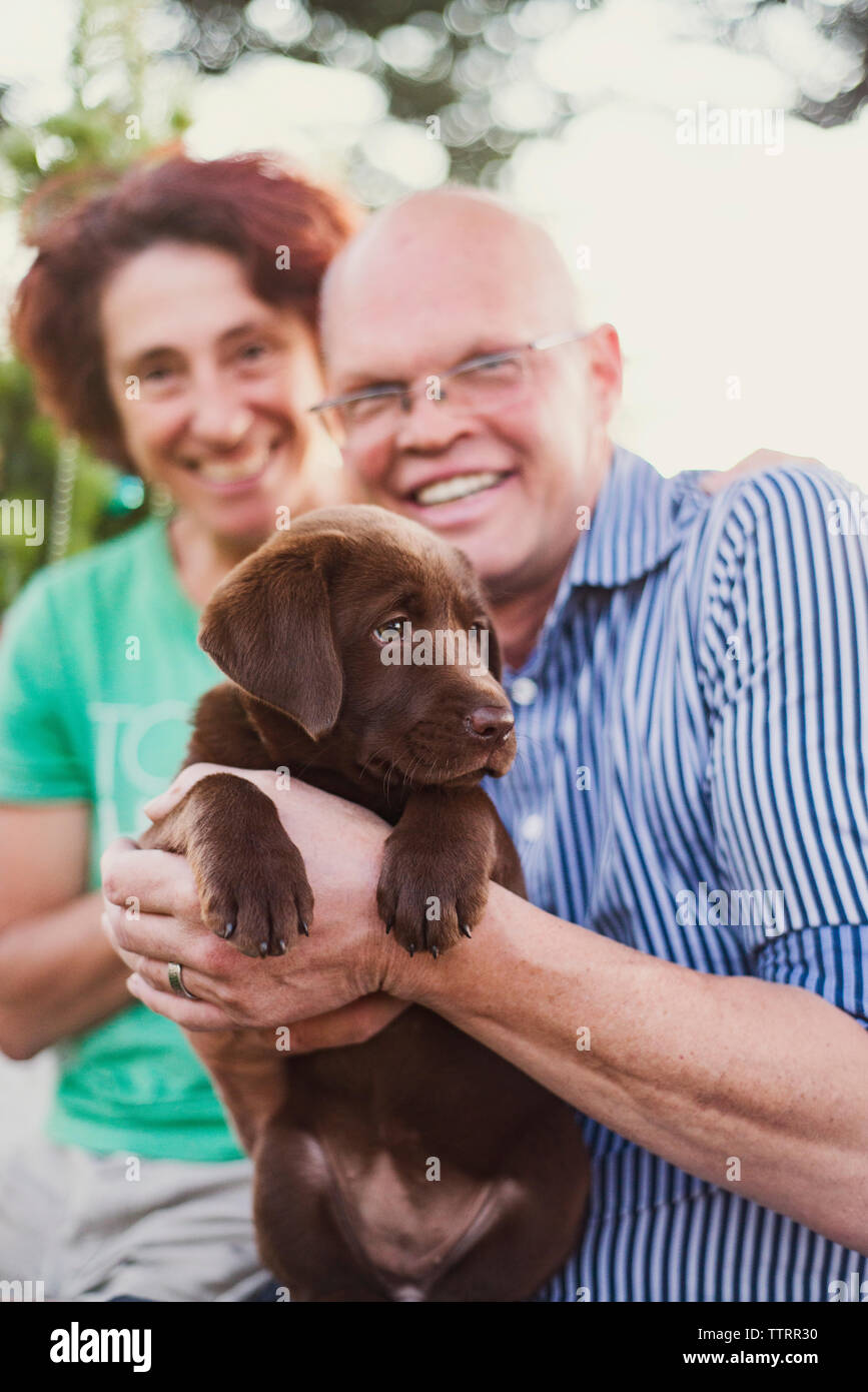 Portrait von lächelnden Reifes Paar mit Hund im Hof Stockfoto