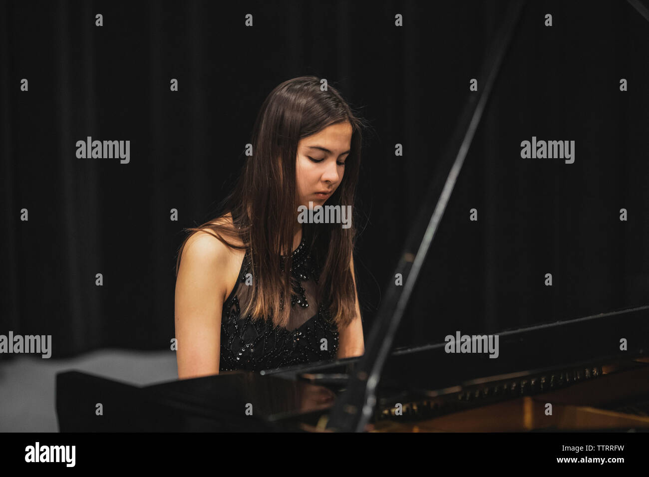 Frau im Abendkleid spielen klassische Musik am Piano. Stockfoto