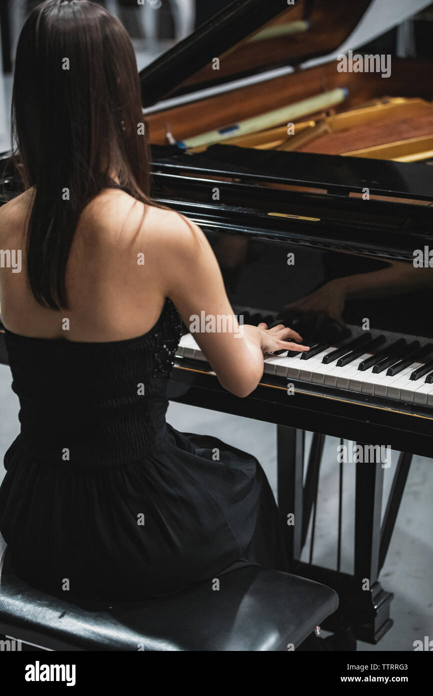 Rückansicht der Frau spielen klassisches Piano auf die Leistung. Stockfoto