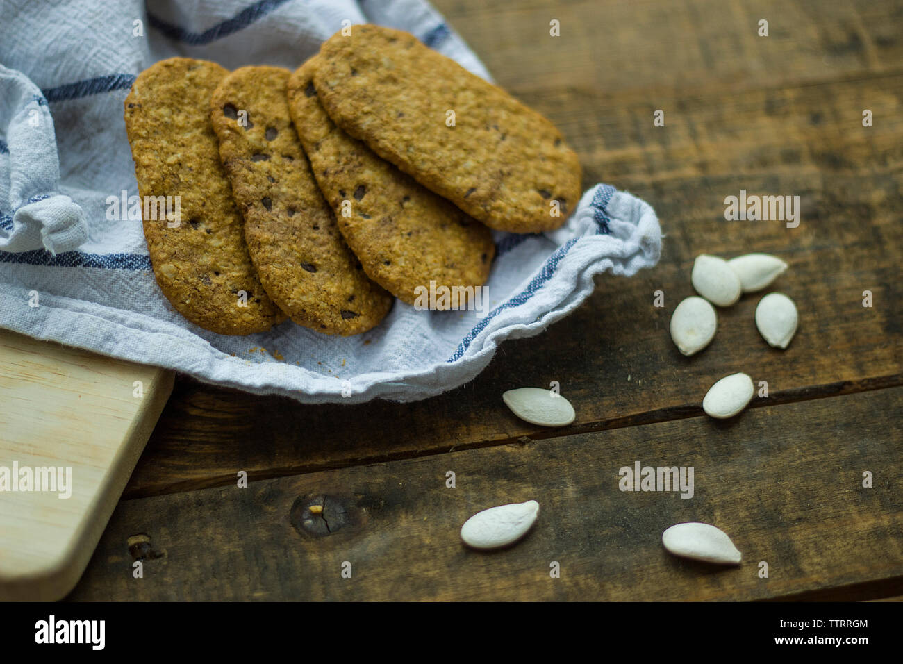 Hohe Betrachtungswinkel von Cookies mit Saatgut und Gewebe auf hölzernen Tisch Stockfoto