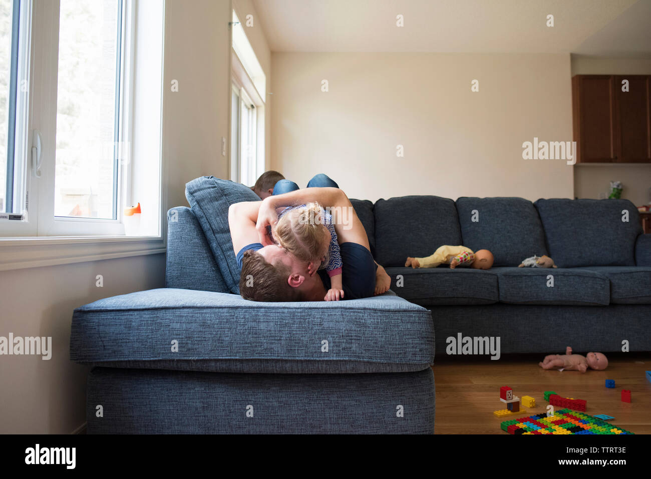 Gerne Vater spielen mit den Kindern auf dem Sofa zu Hause Stockfoto