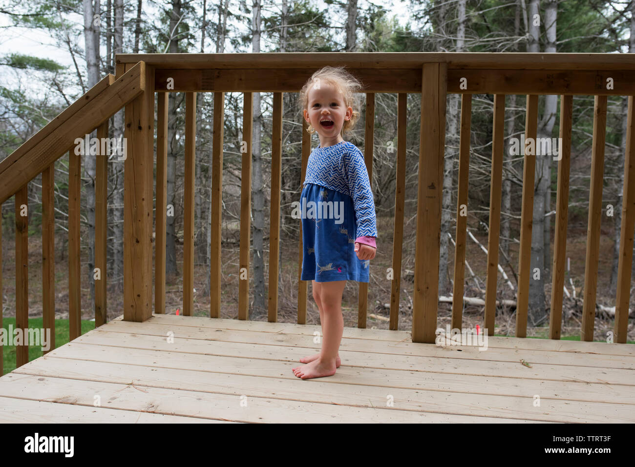 Portrait von fröhliches Mädchen stehend durch Geländer Stockfoto