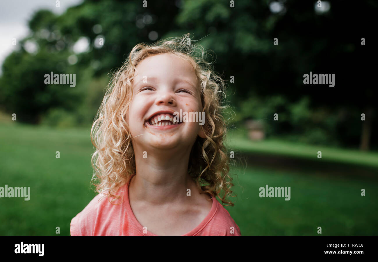Cute fröhliches Mädchen weg schauen im Park Stockfoto
