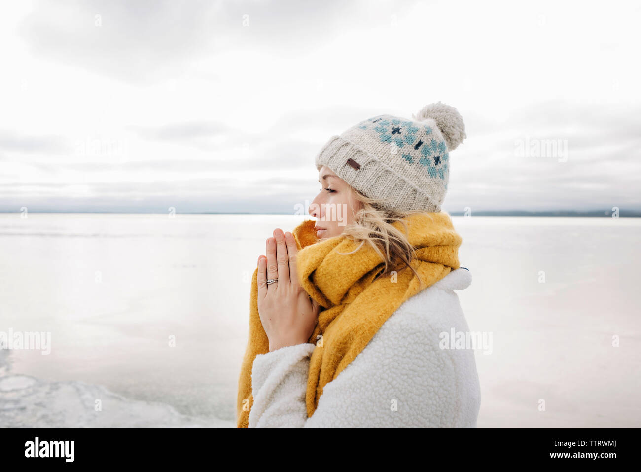 Portrait von blonde Frau hält ihre Hände warm am Strand im Winter Stockfoto