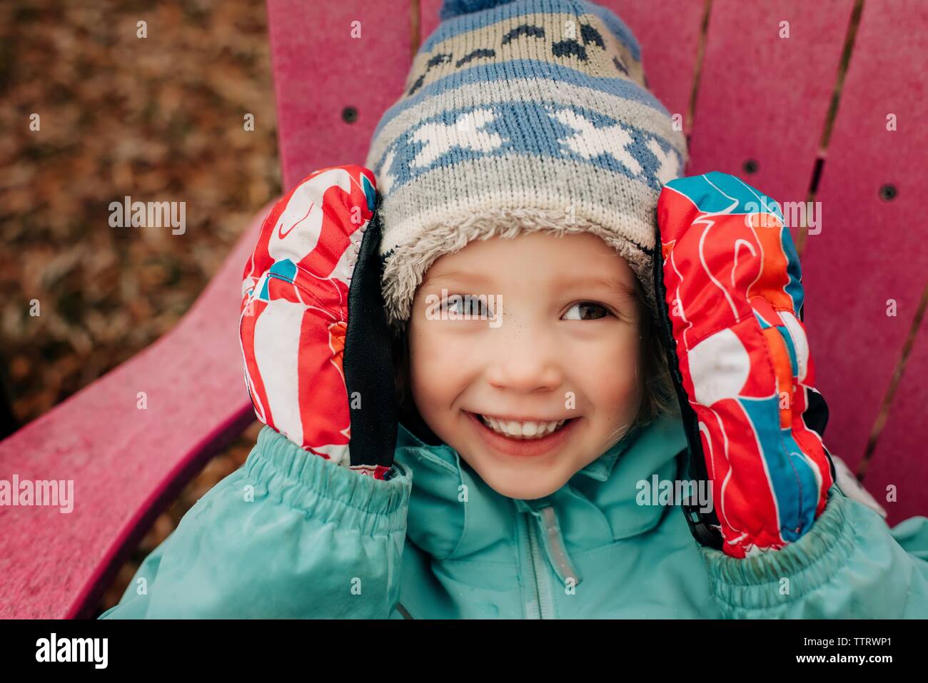 Porträt der jungen Mädchen im Alter von 4 lächelnd mit hut, handschuhe und Mantel Stockfoto