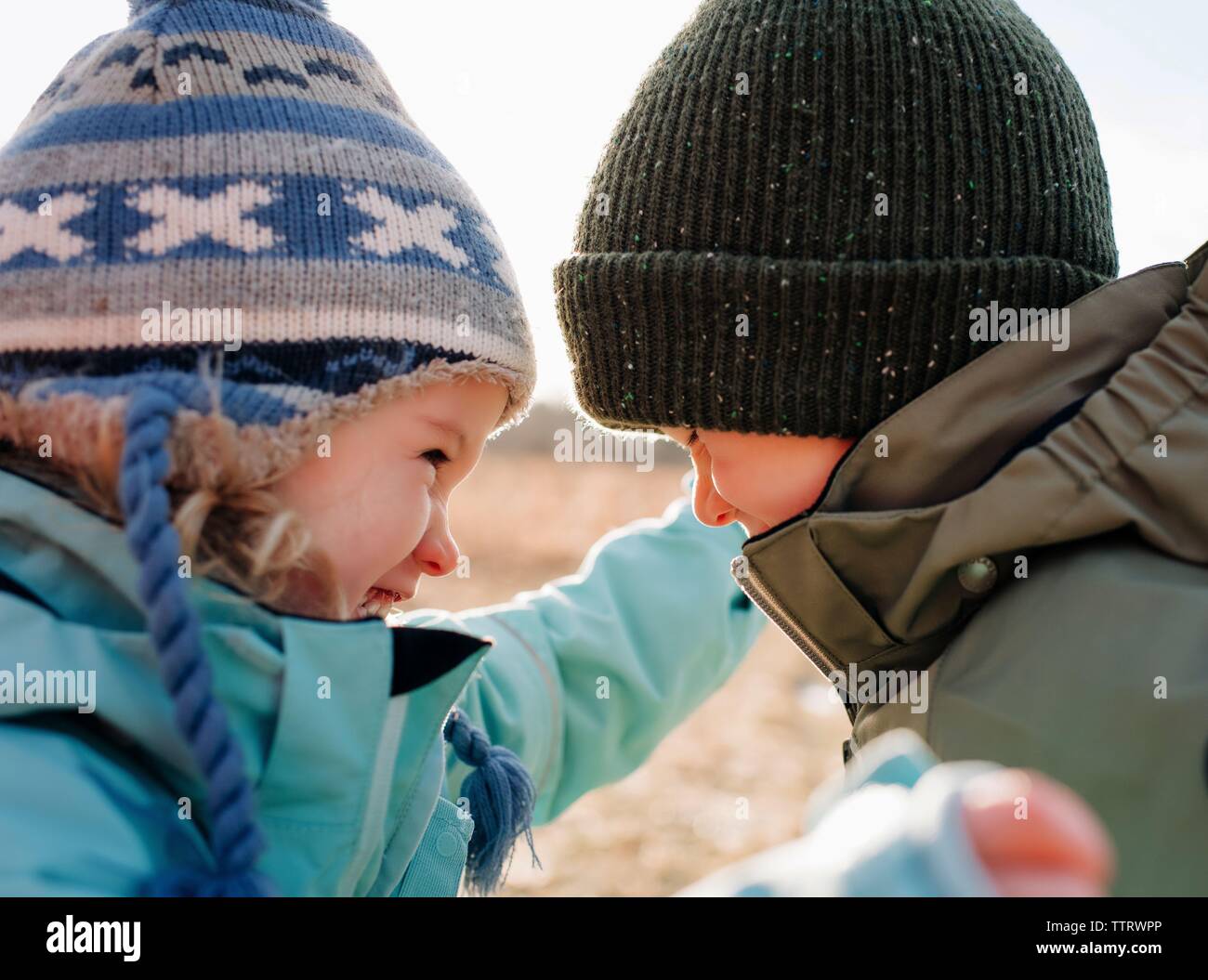 Bruder und Schwester zusammen lachen in hun Spielen im Freien Stockfoto