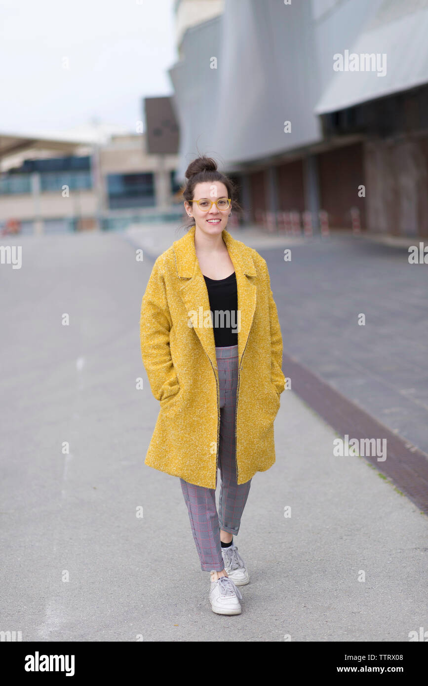 Portrait von zuversichtlich Geschäftsfrau mit Händen in den Taschen zu Fuß auf der Straße Stockfoto