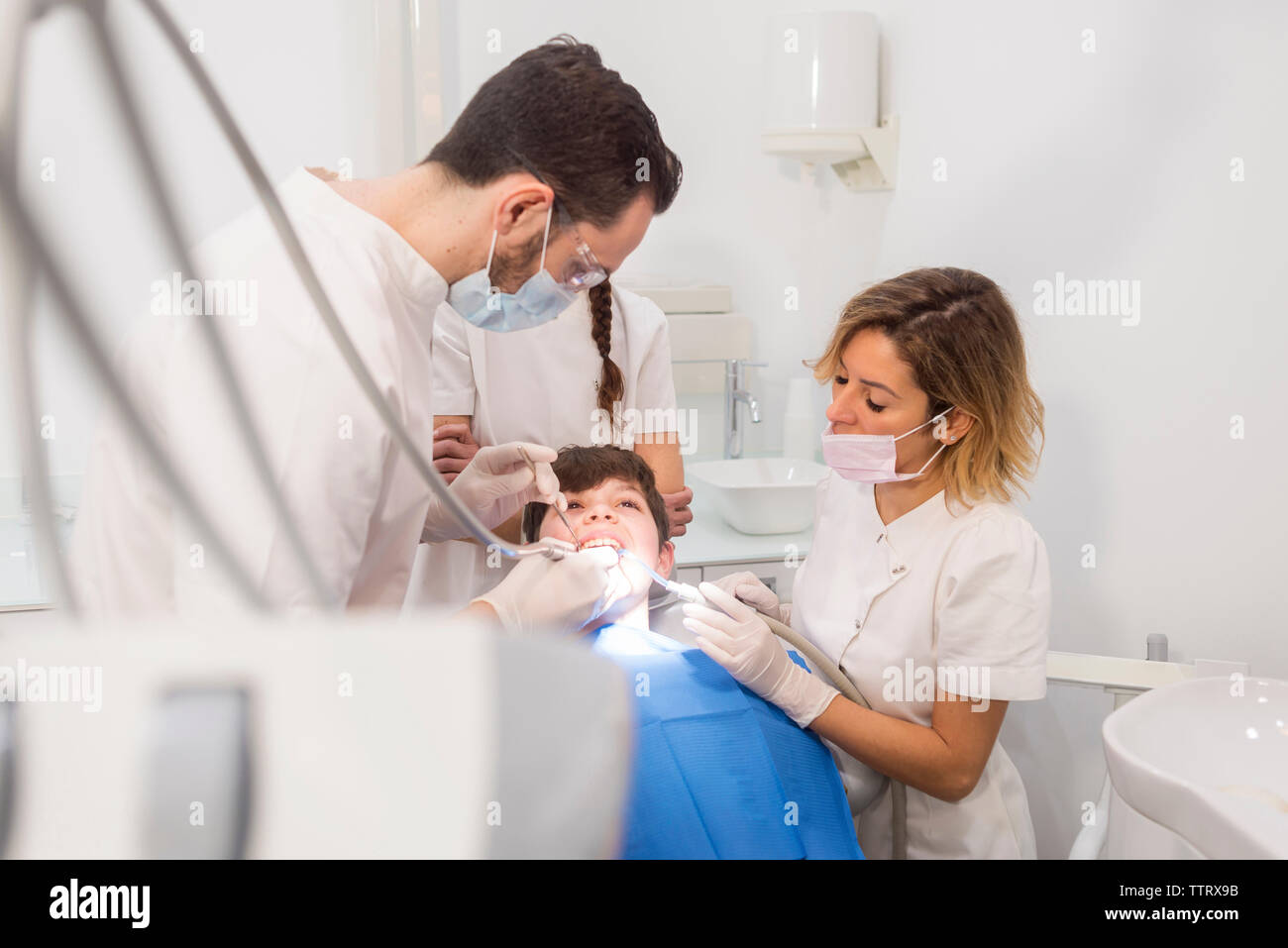 Assistenten helfen Zahnarzt bei der Prüfung der Zähne des Patienten in der Medizinischen Klinik Stockfoto