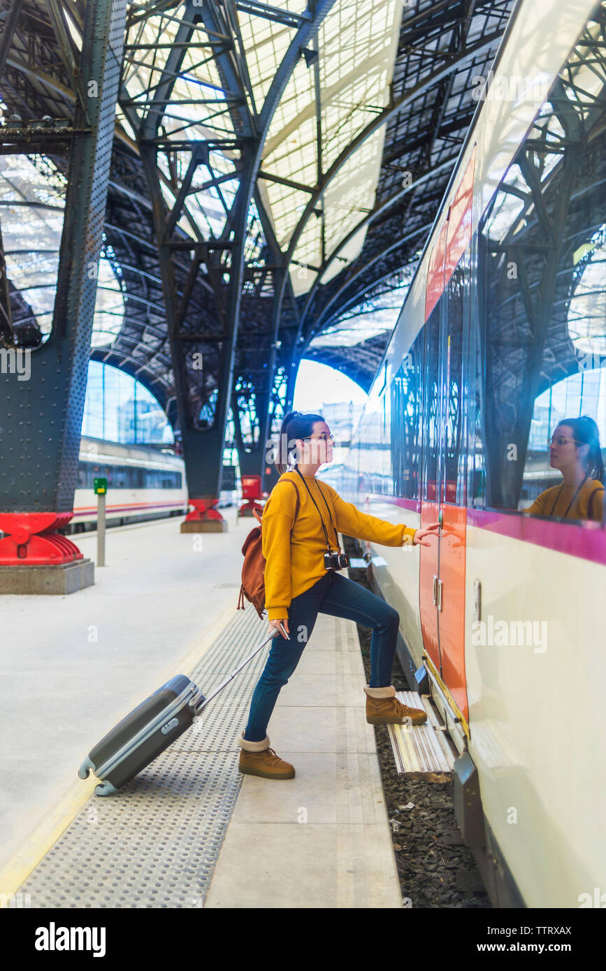 Seitenansicht der Frau mit Gepäck in der Bahn am Bahnhof Plattform Stockfoto