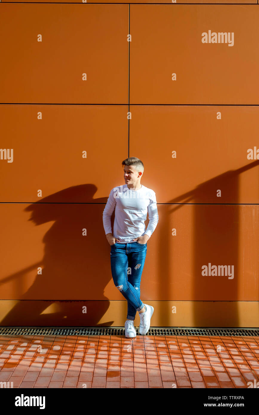 Vorderansicht junger Mann lehnte sich an die Wand, während Sie auf der Suche Stockfoto