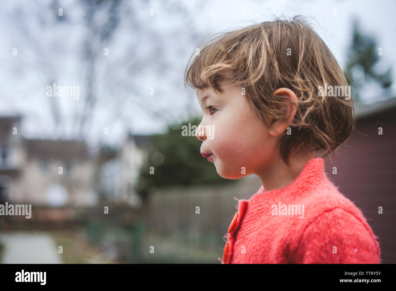 Seitenansicht von Nachdenklich Baby Mädchen suchen, während sie sich gegen Himmel im Herbst Stockfoto