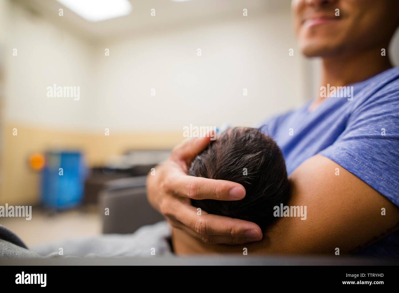 Ein stolzer, ein Lächeln auf den neuen Vater Ladestationen ist neugeborene Tochter in seine Arme Stockfoto