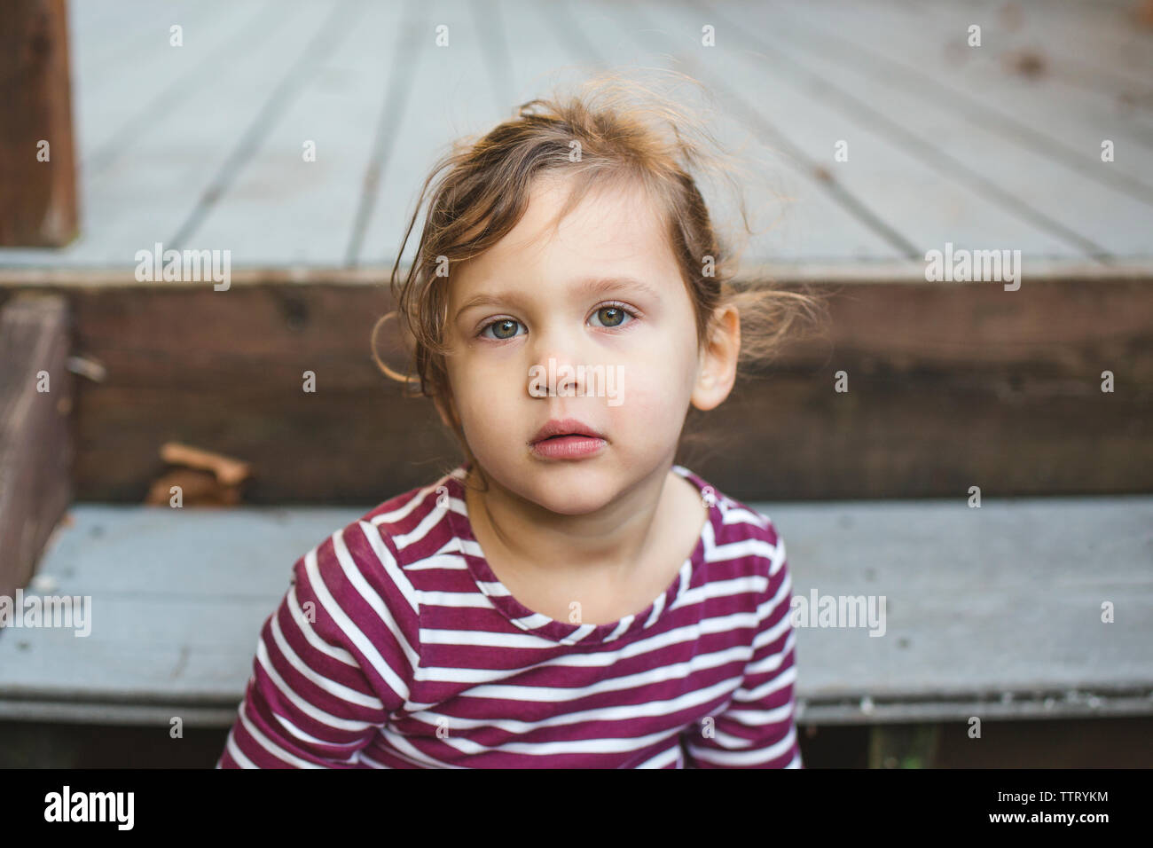 Eine schöne Kleinkind Mädchen mit wispy Locken schaut direkt in die Kamera Stockfoto