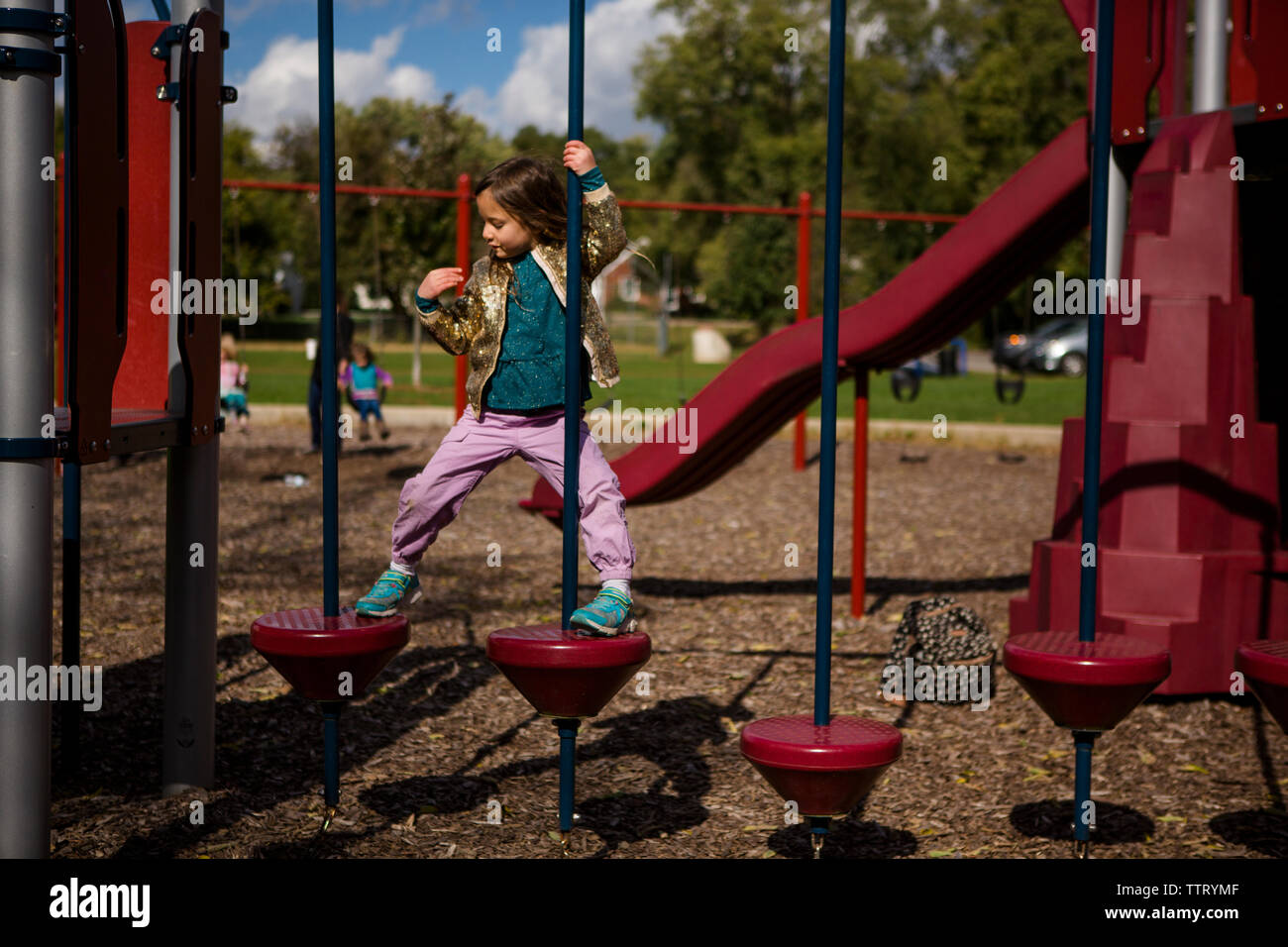 Eine stolze unabhängige kleine Mädchen klettert auf einem Spielplatz Stockfoto