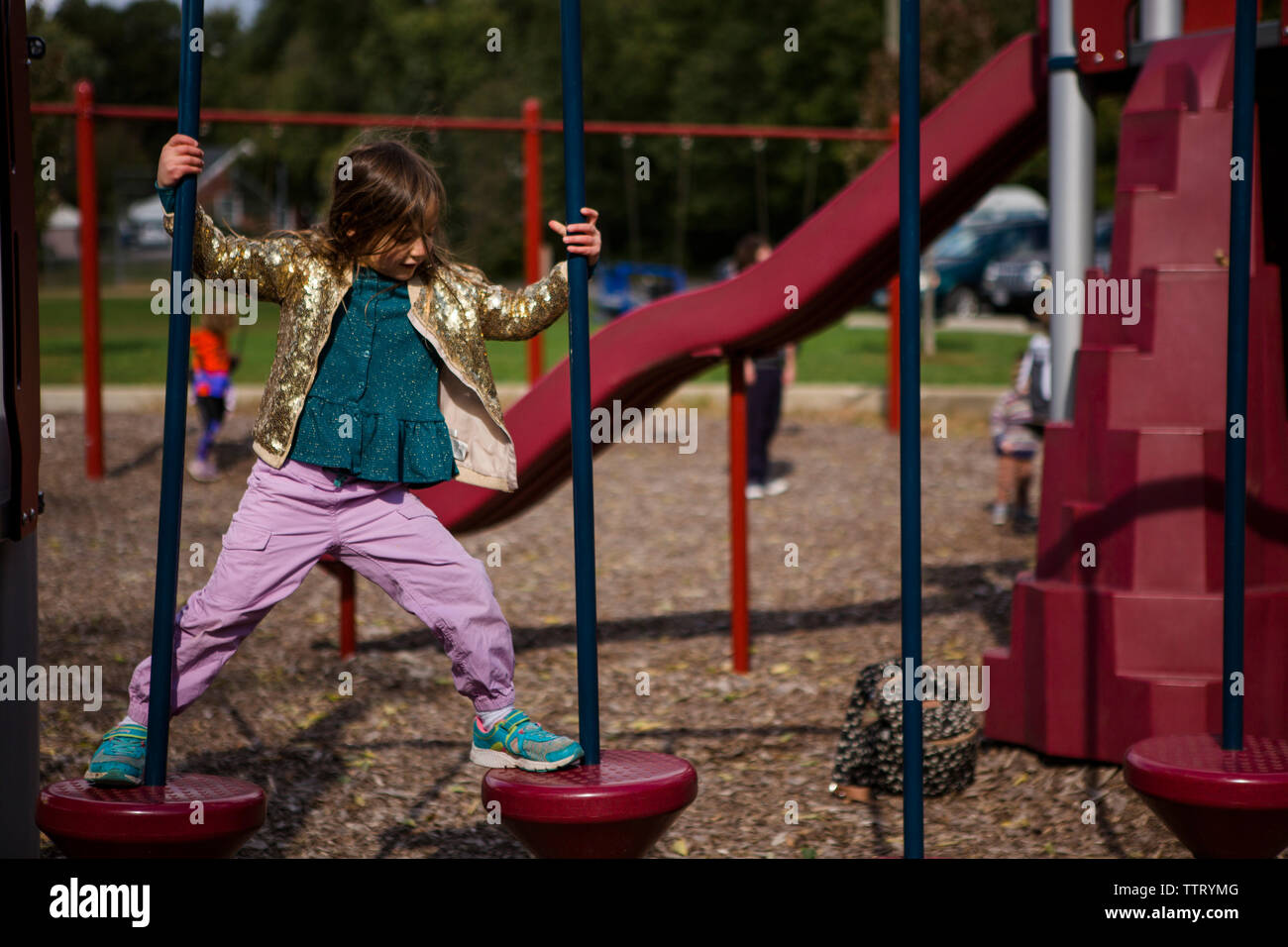 Eine stolze kleine Mädchen lernt einen neuen Skill auf einem Spielplatz Stockfoto