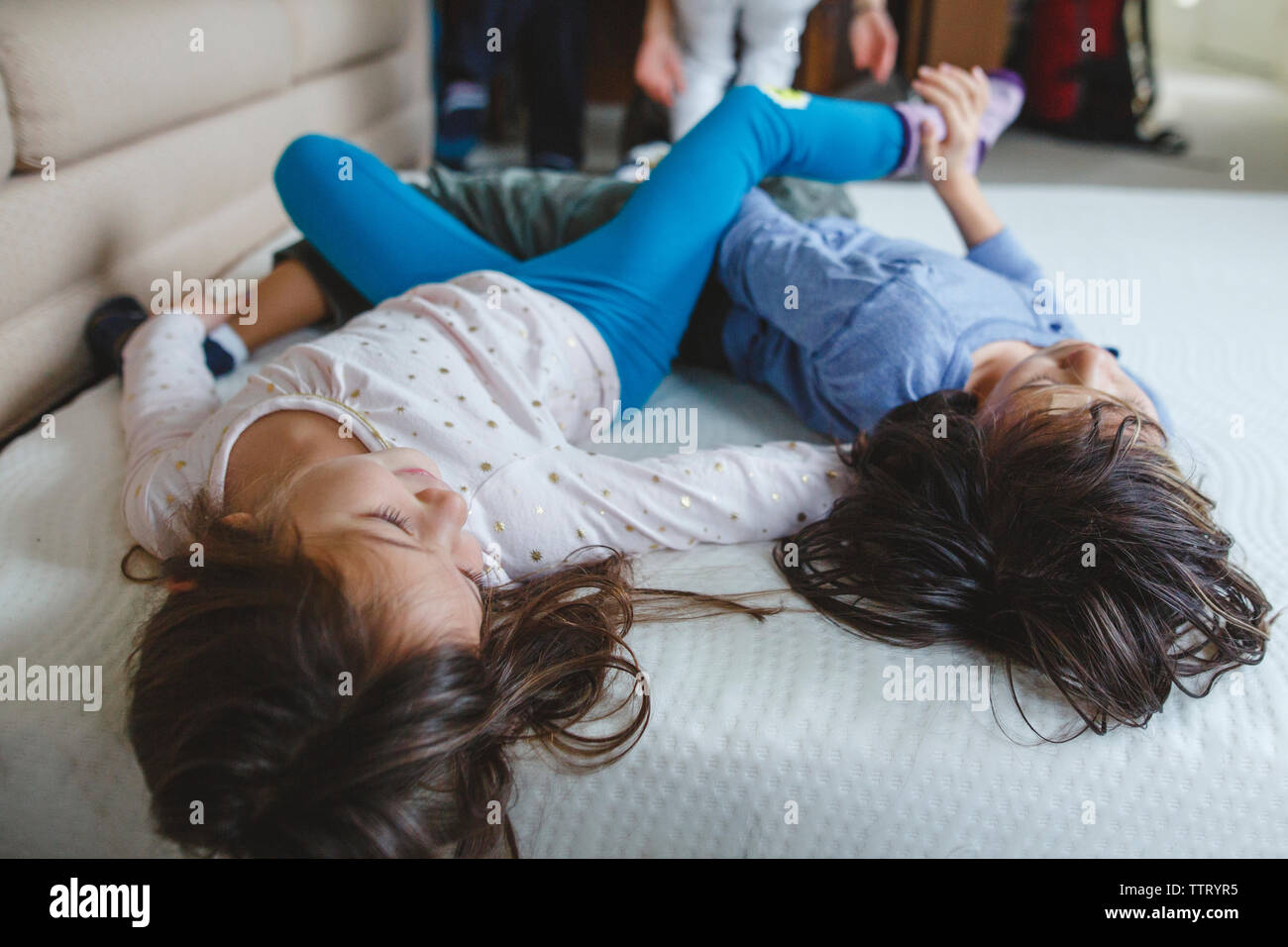 Gerne Geschwister Festlegung auf der Matratze auf dem Boden spielen Stockfoto