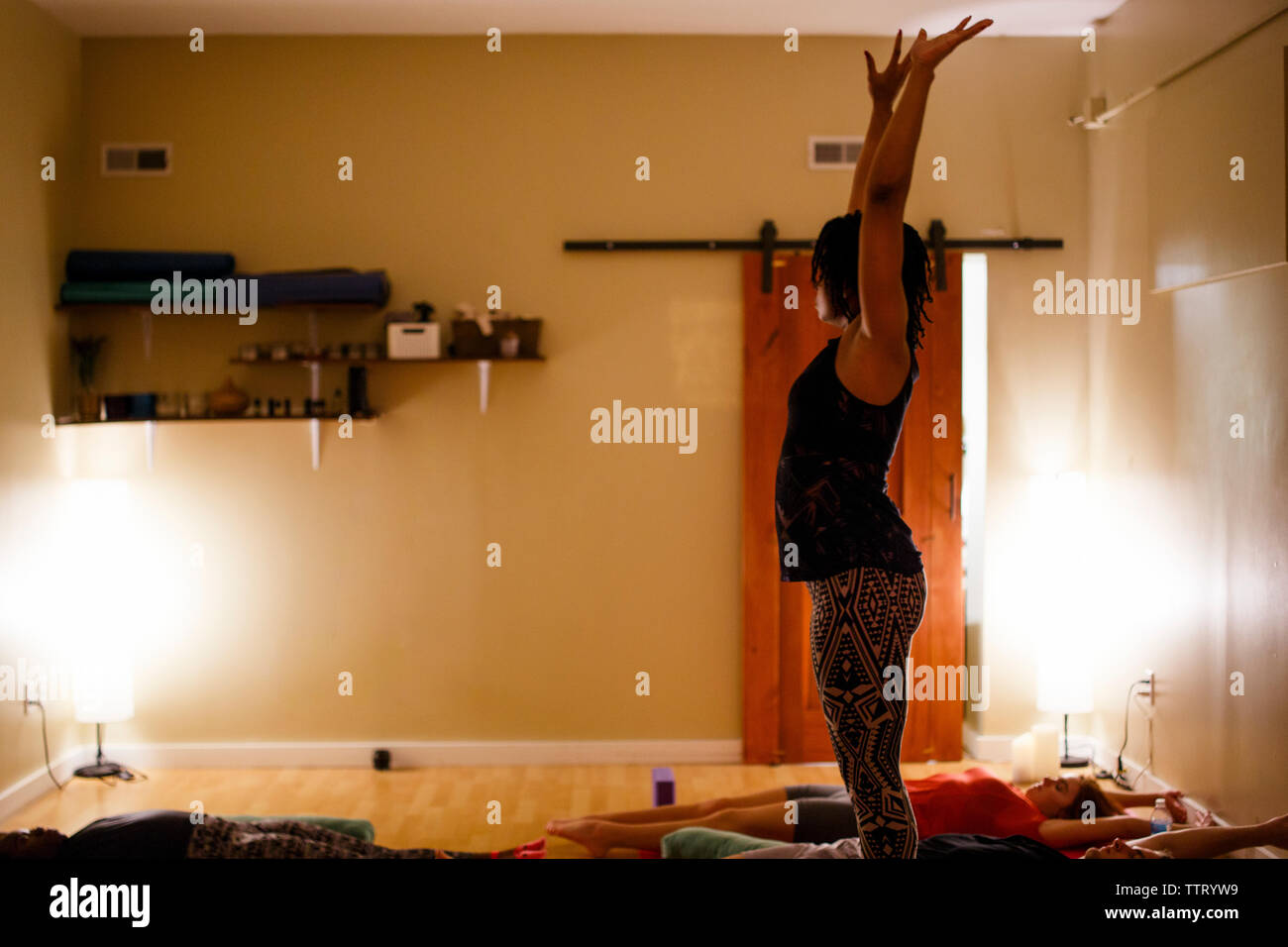 Ein yoga Kursleiter führt die Teilnehmer durch friedliche Meditation Stockfoto