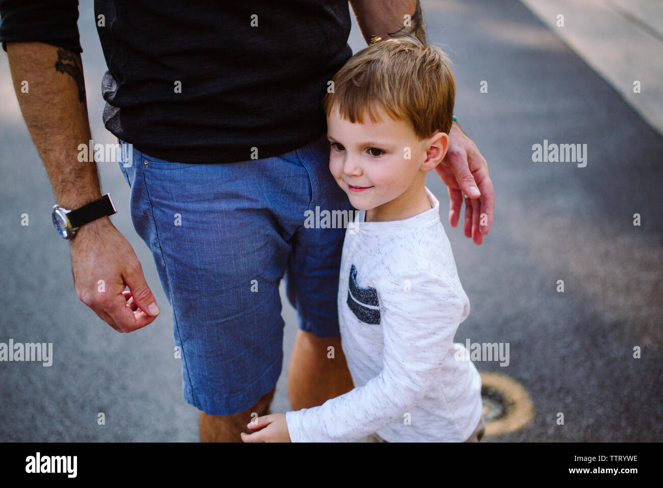 Porträt eines kleinen Jungen an Bein seines Vaters Stockfoto