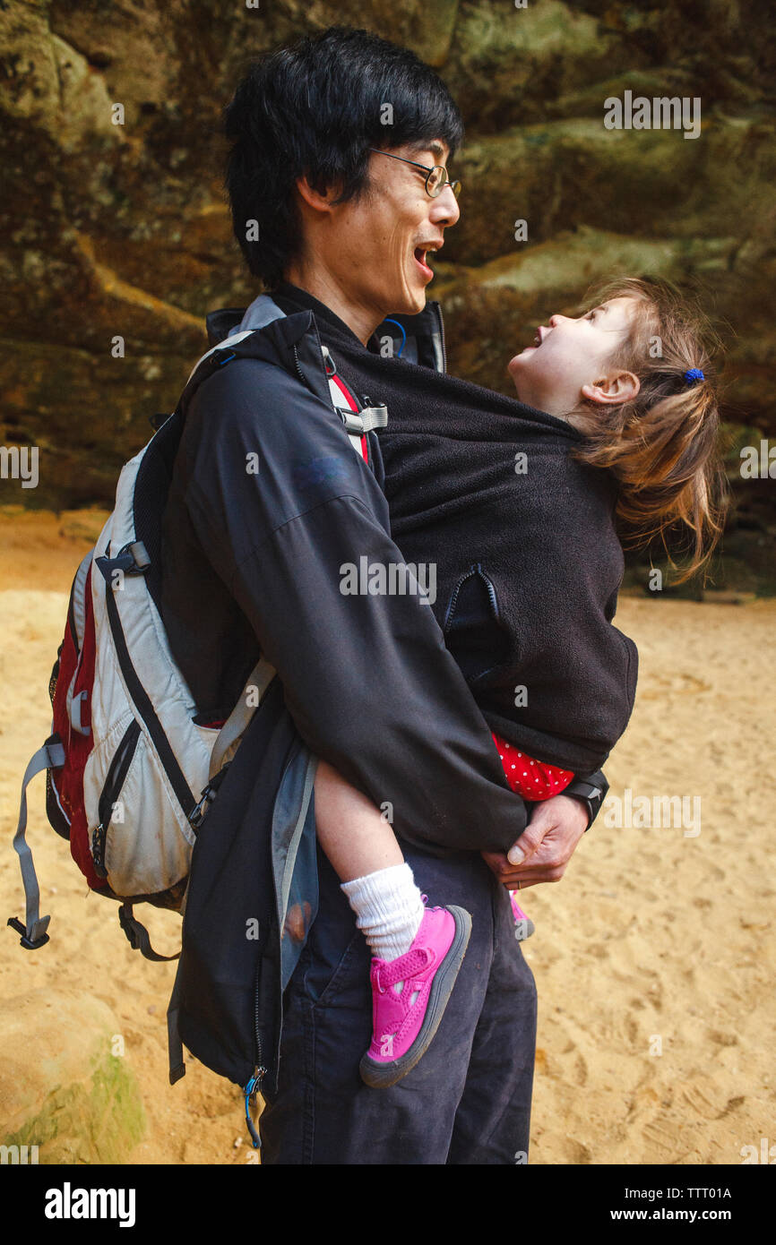 Portrait eines glücklichen Vater mit seinem kleinen Mädchen in seinem Mantel versteckt Stockfoto