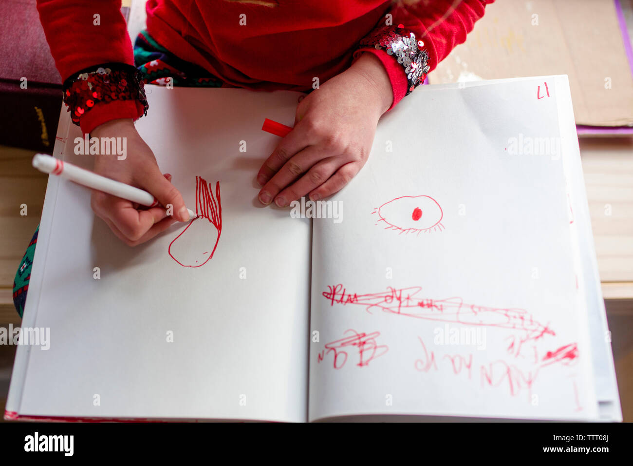 Oben Blick auf ein kleines Mädchen Zeichnen von Bildern mit einem roten Marker Stockfoto