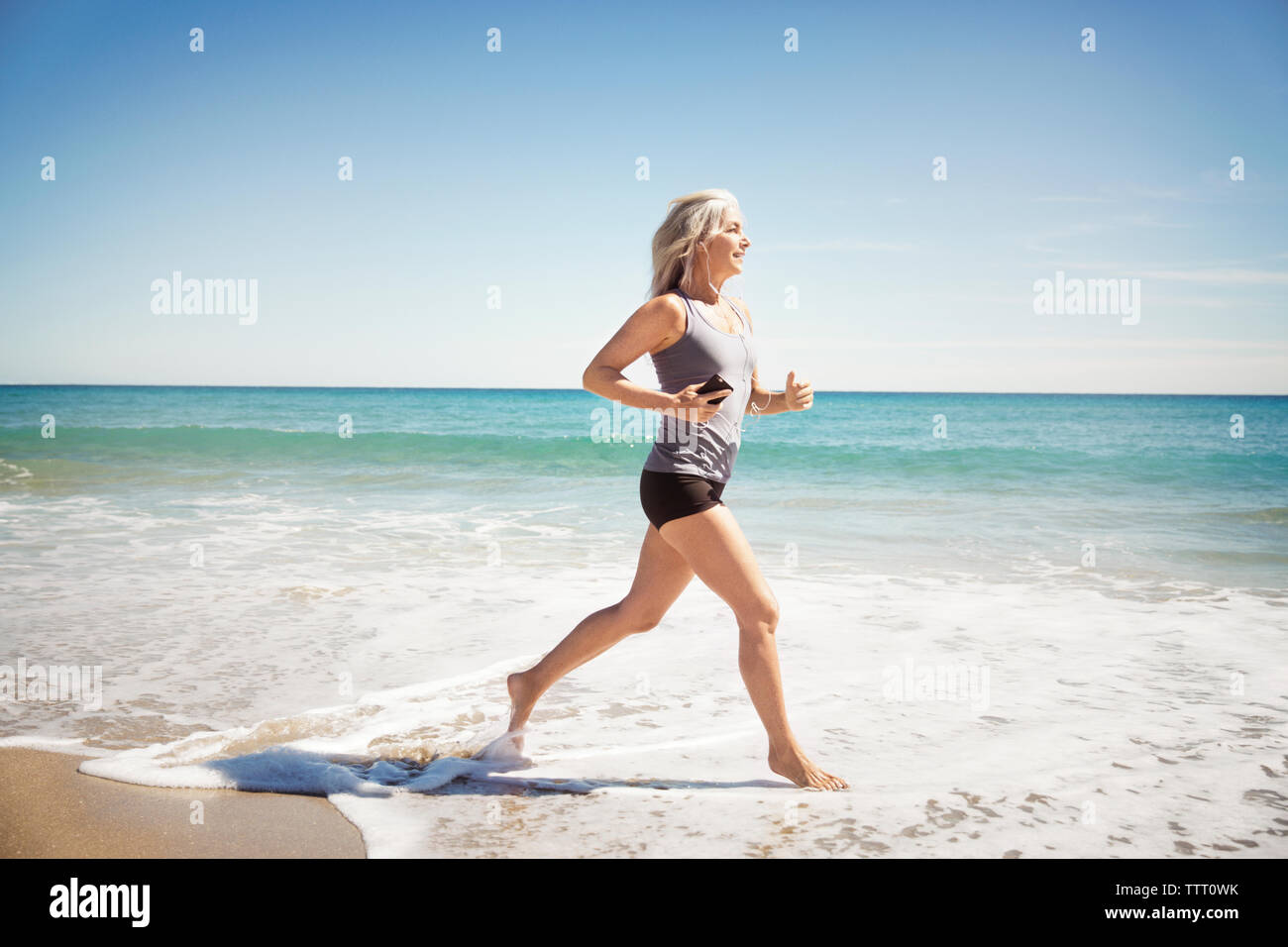 Die ganze Länge der reifen Frau joggen am Meer in Delray Beach Stockfoto