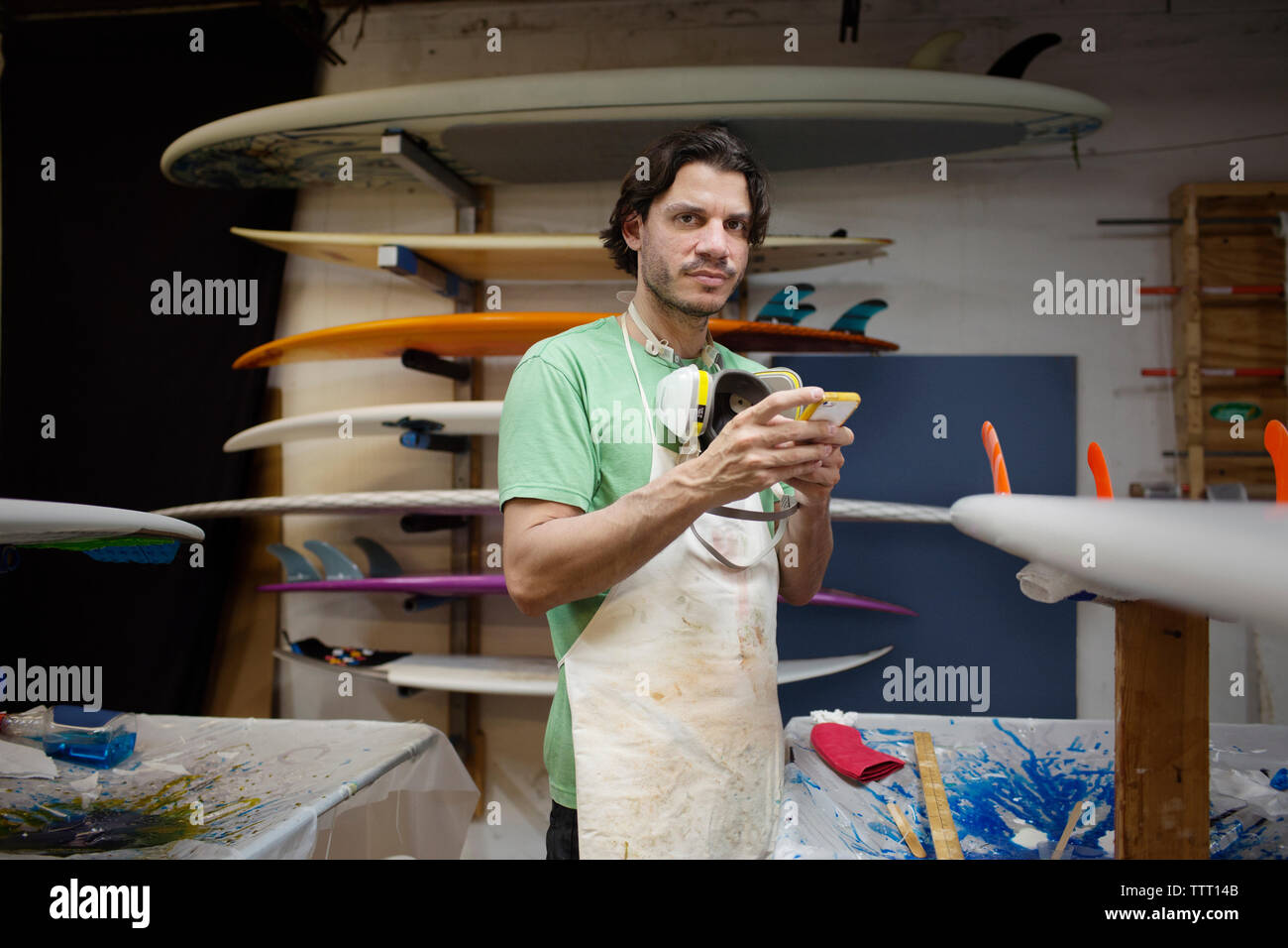 Portrait der männlichen mit Phone beim Stehen in der Werkstatt Arbeitnehmer Stockfoto