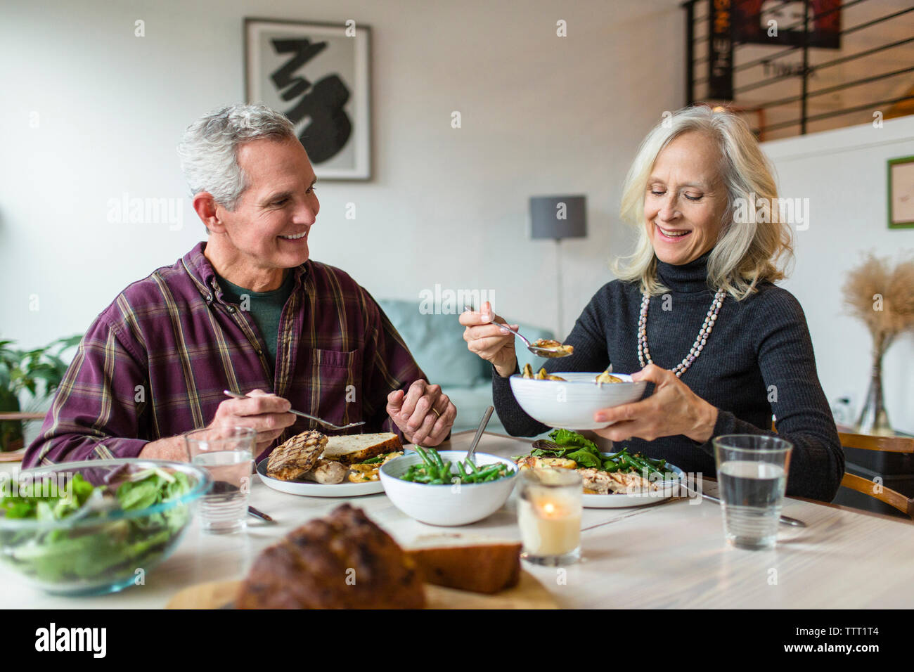 Lächelndes Paar beim Mittagessen in Esstisch Stockfoto