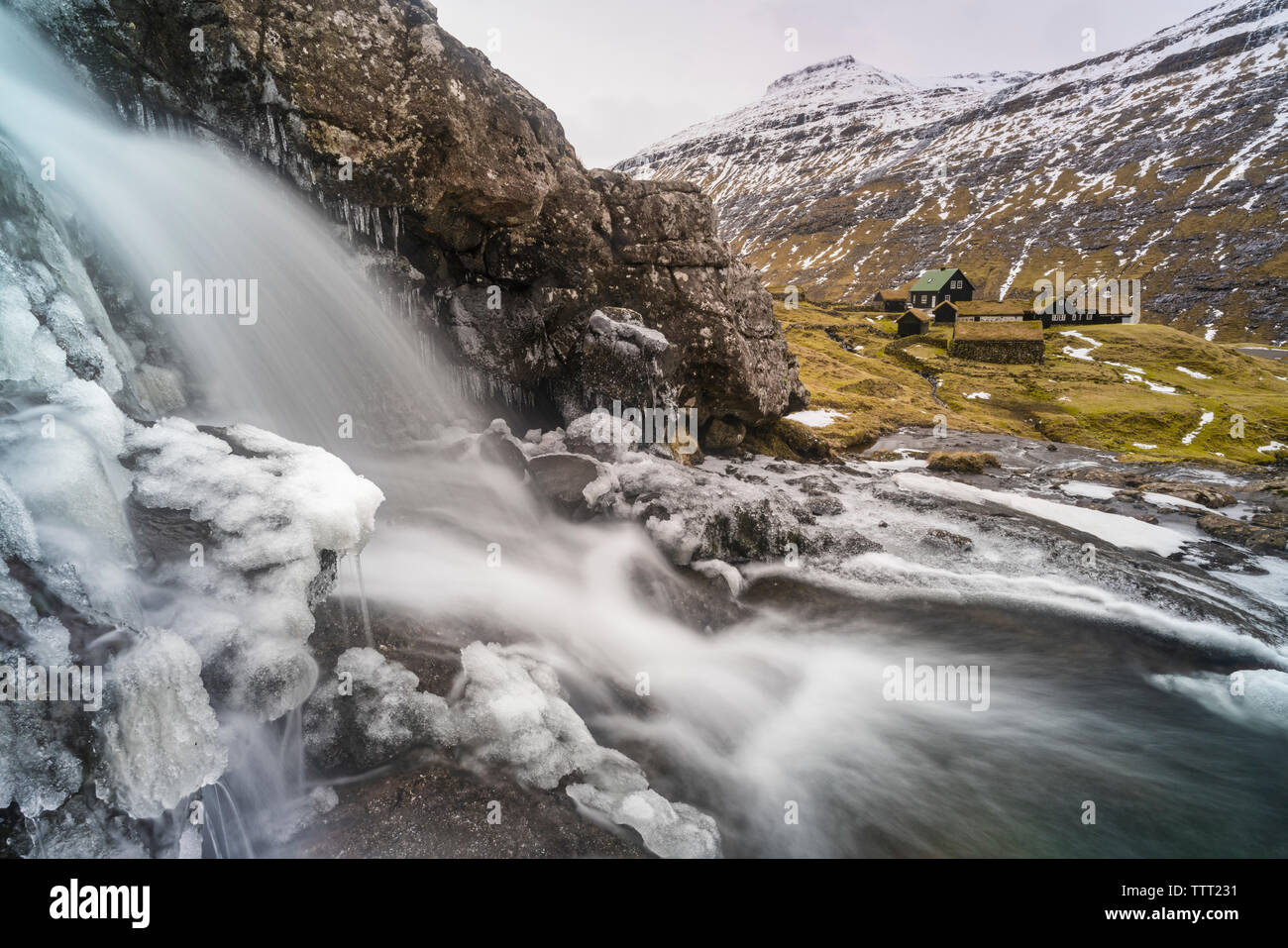 Plätschernden Wasserfall über Felsen bedeckt mit Eis, Saksun, Streymoy Island, Färöer, Dänemark Stockfoto
