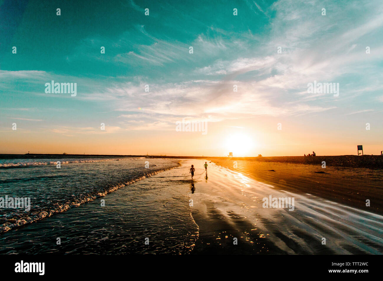 Ansicht der Rückseite des Menschen läuft am Ufer bei Sonnenuntergang Stockfoto