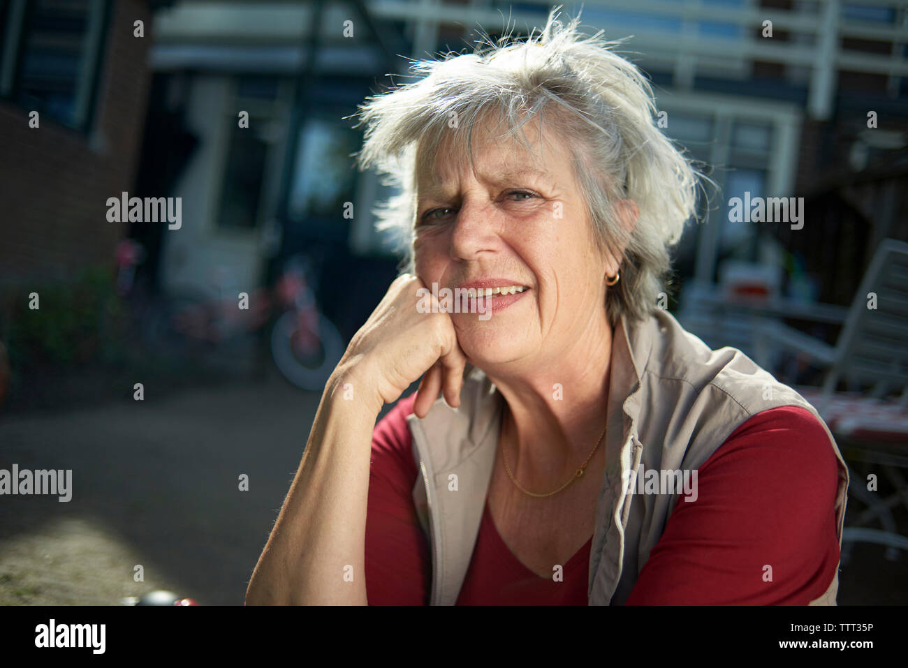 Portrait von lächelnden älteren Frau im Hof sitzen Stockfoto