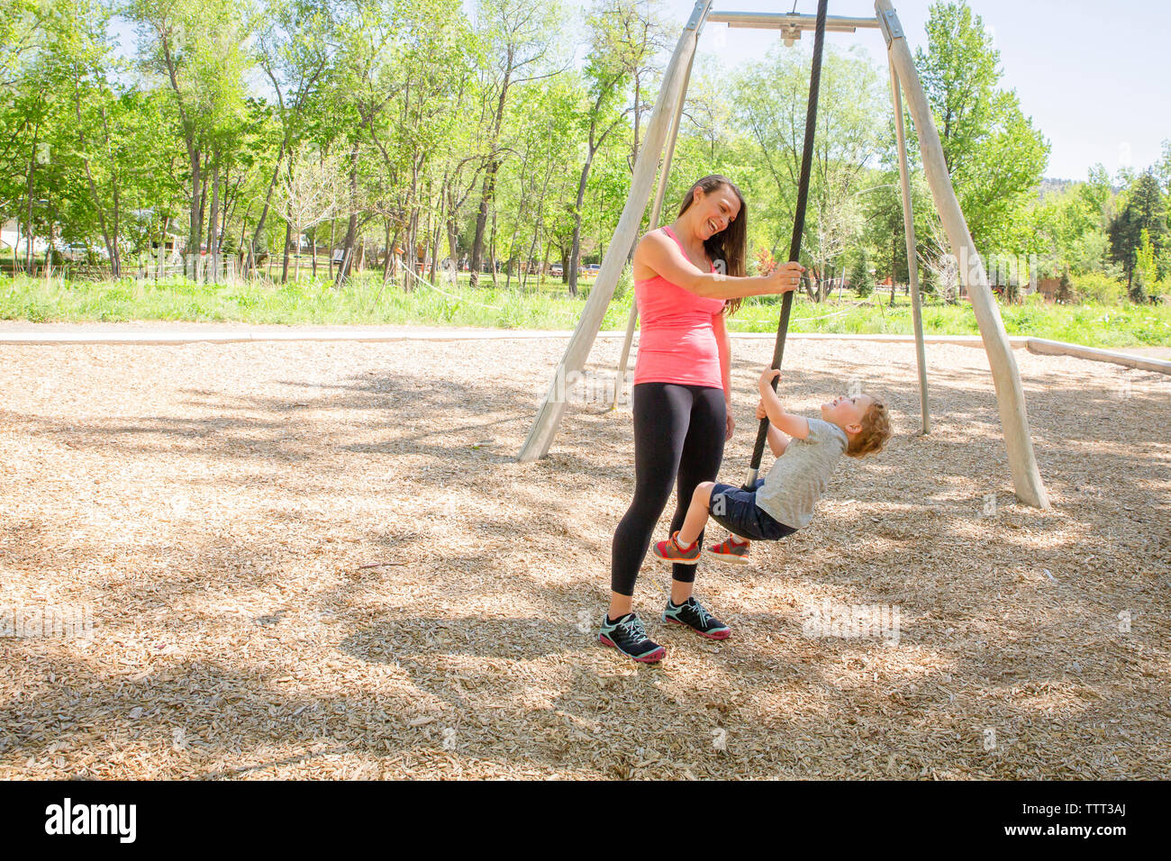 Glückliche Mutter und Sohn spielen am Spielplatz Stockfoto
