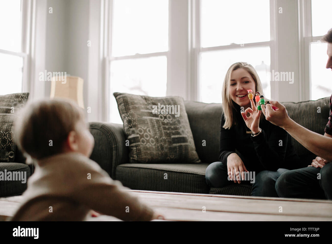 Glückliche Eltern, Spielzeug auf den Sohn beim Sitzen auf dem Sofa zu Hause Stockfoto