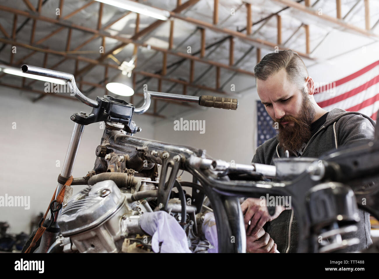 Ernsthafte Mechaniker arbeiten am Motorrad an Werkstatt Stockfoto