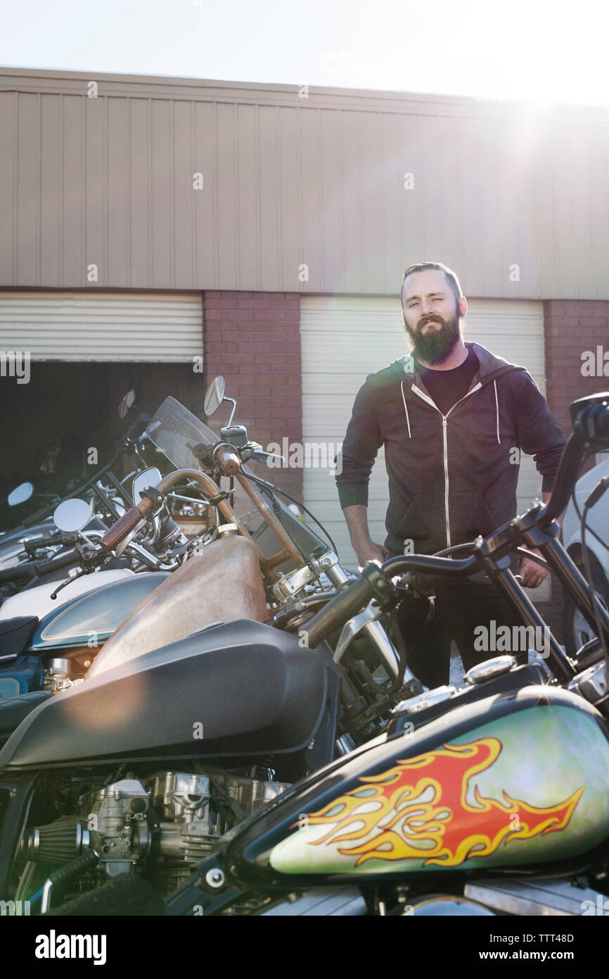 Zuversichtlich Mechaniker stehen Motorräder außerhalb des Shops Stockfoto