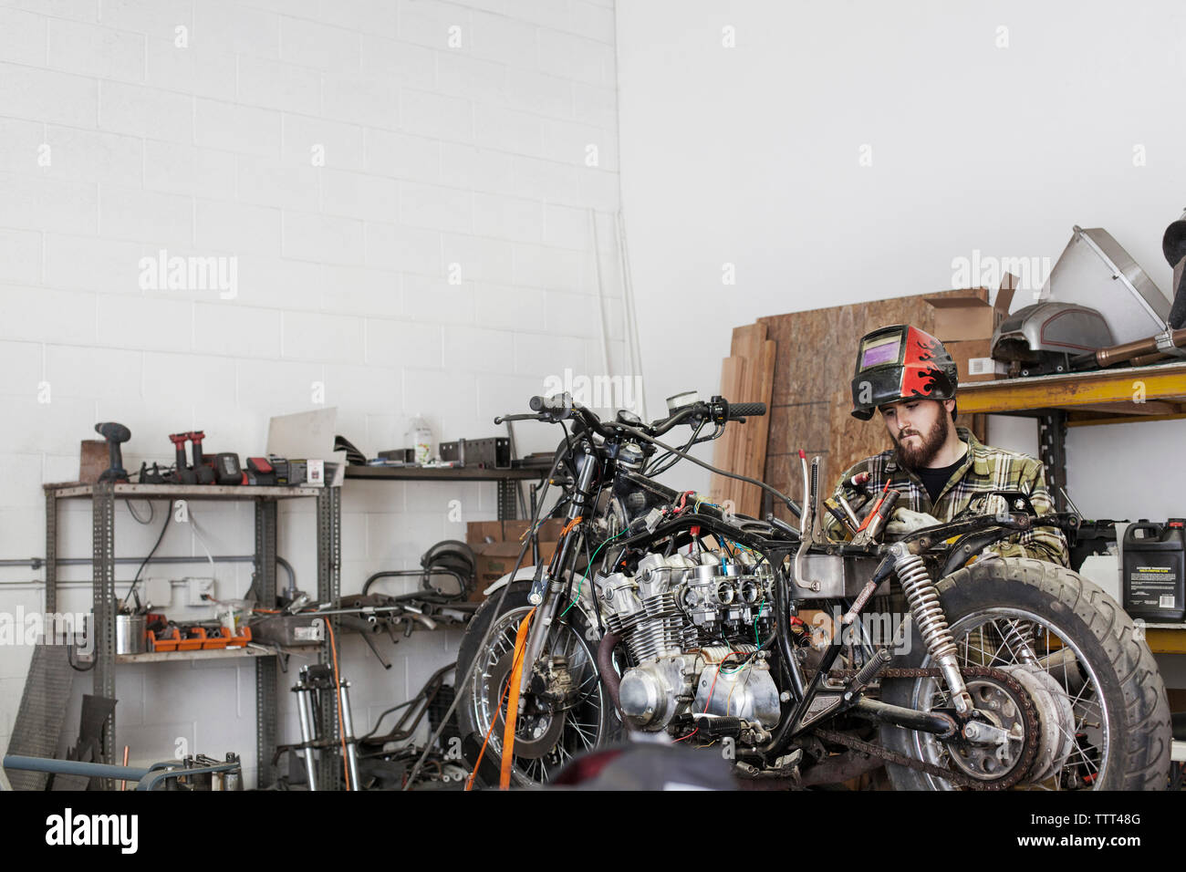 Ernsthafte Mechaniker arbeiten am Motorrad an Werkstatt Stockfoto