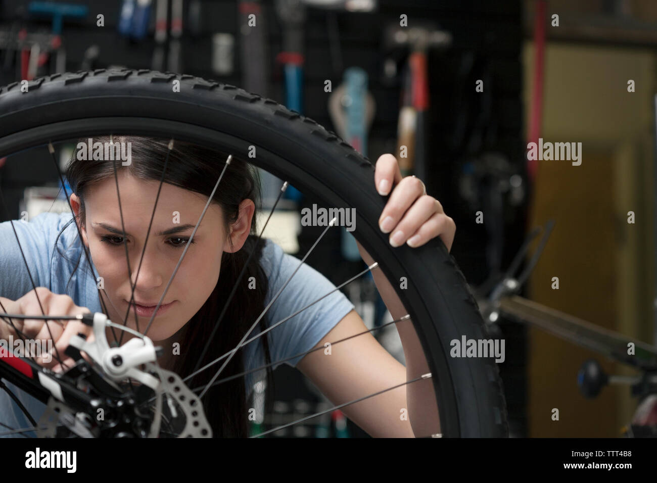 Frau zur Festsetzung Fahrrad Bremse in der Werkstatt Stockfoto