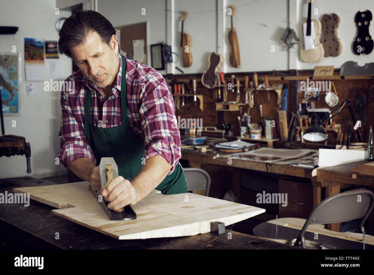 Man Sägen von Holz bei der Violine in der Werkstatt Stockfoto