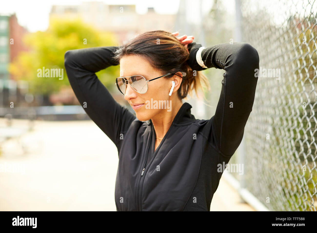 Eine sportliche Frau, die ihre Haare nach hinten ziehen. Stockfoto