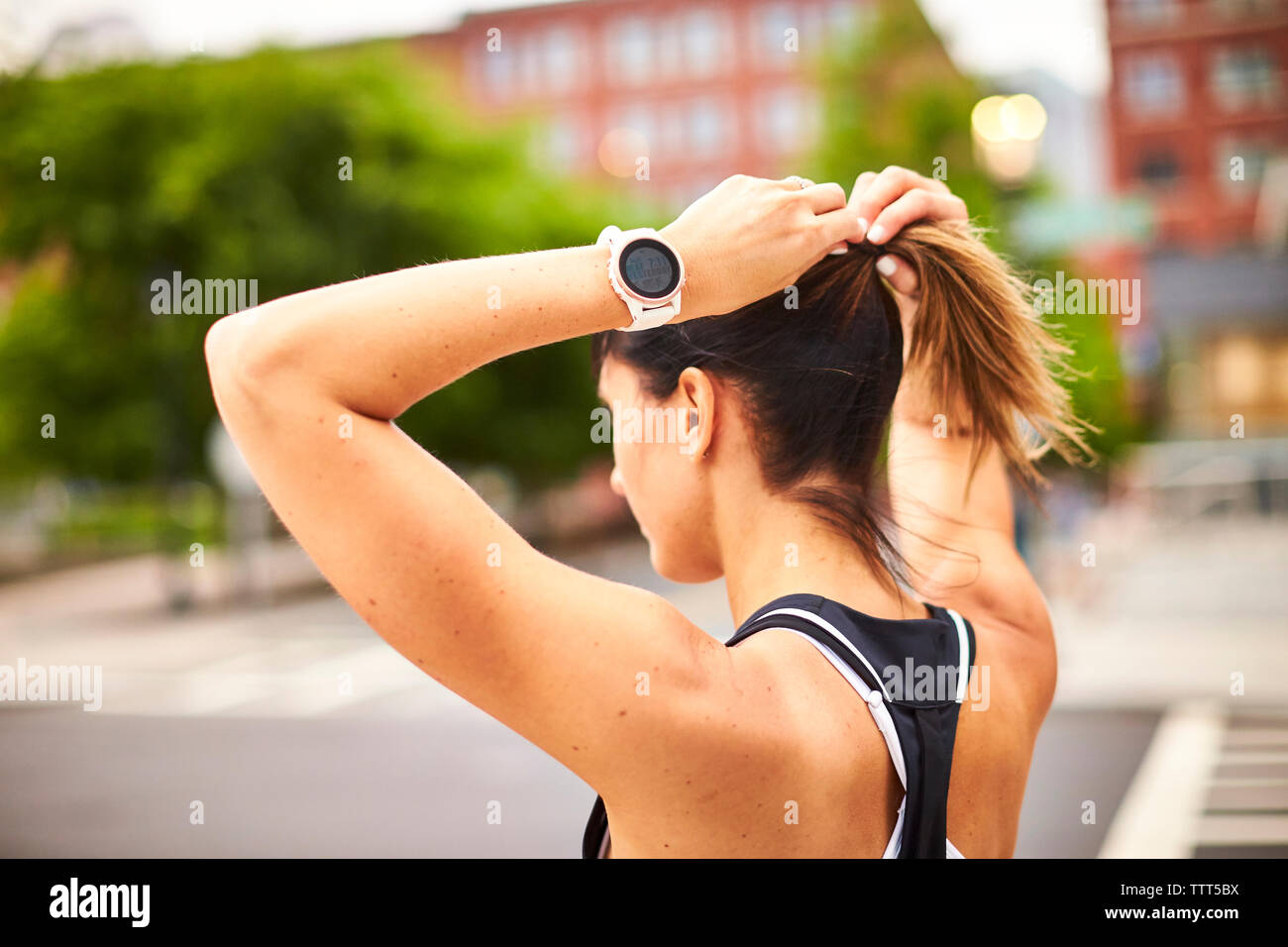 Eine sportliche Frau, Ihren Pferdeschwanz einstellen. Stockfoto