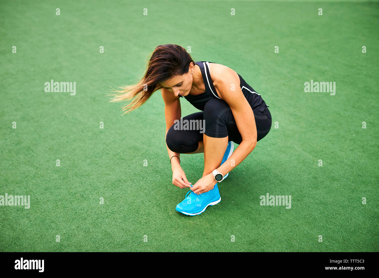 Eine sportliche Frau, die ihre Turnschuhe binden. Stockfoto