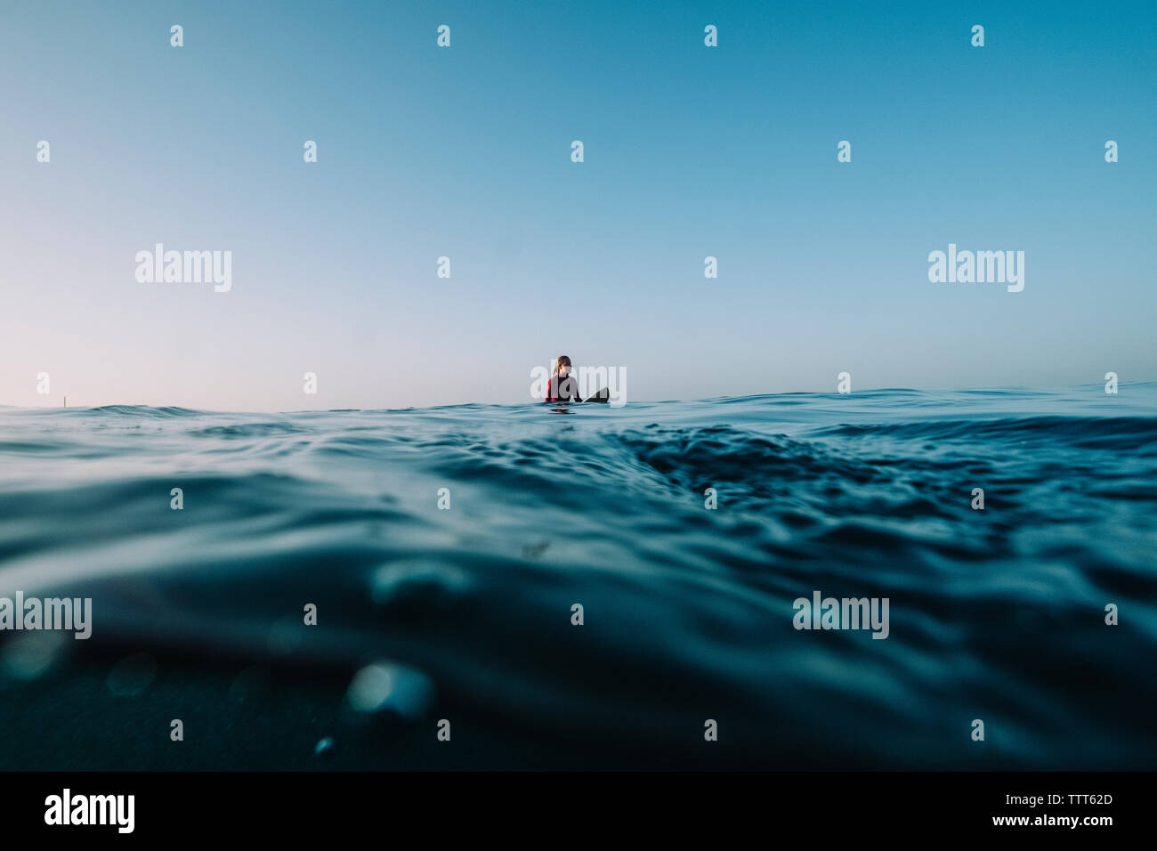 Eine weibliche Surfer wartet auf eine Welle an der Aufstellung Stockfoto