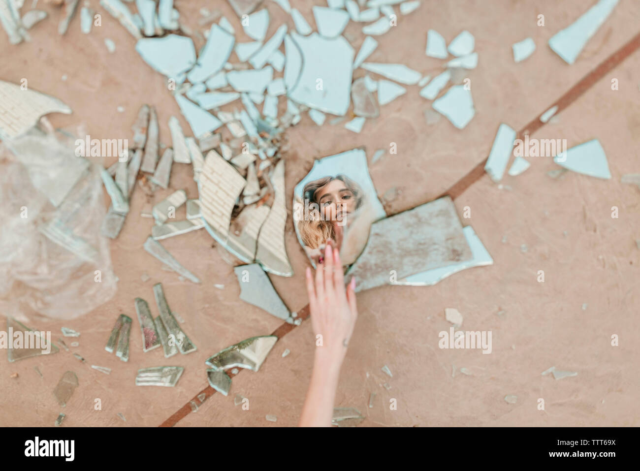 7/8 Hand der Frau berühren Broken Mirror Stücke auf Fußweg Stockfoto 7/8 Hand der Frau berühren Broken Mirror Stücke auf Fußweg Stockfoto