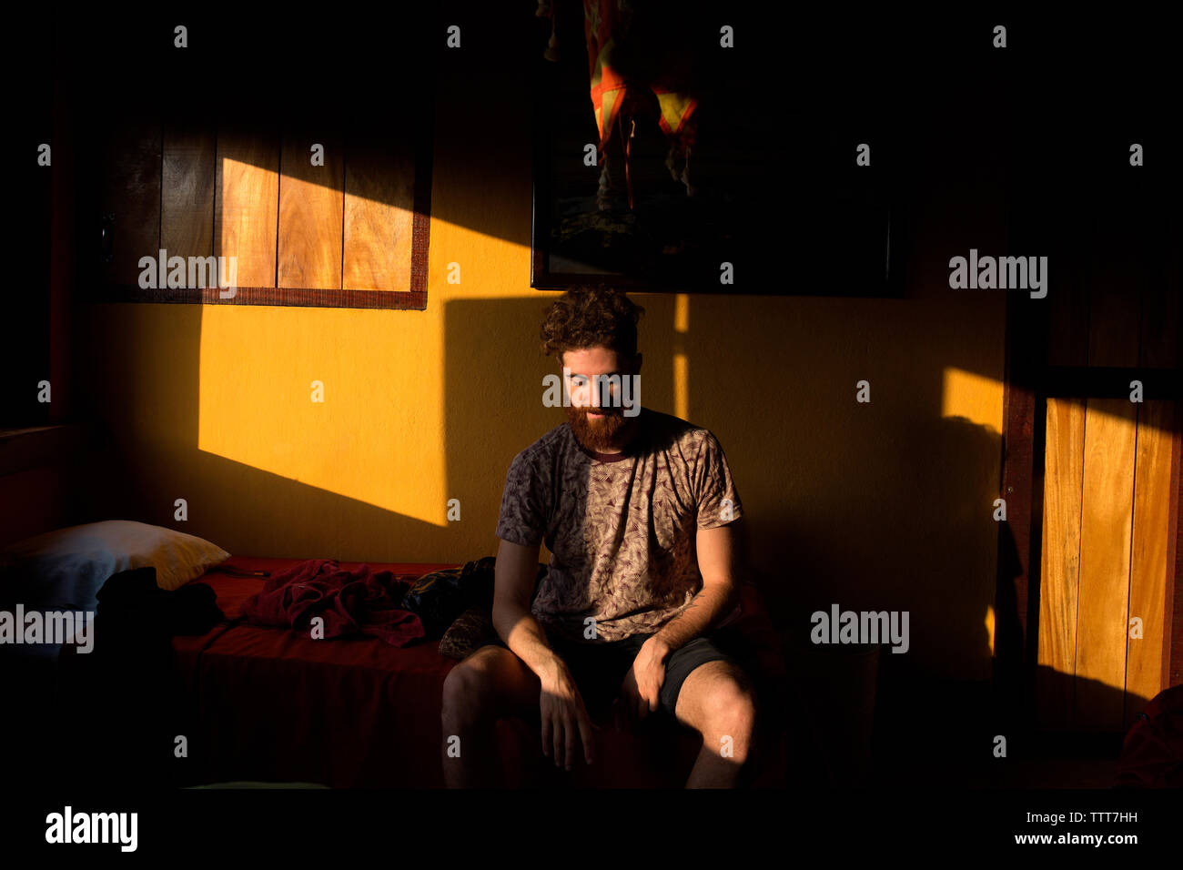 Mann in einem Zimmer im Morgenlicht sitzen Stockfoto