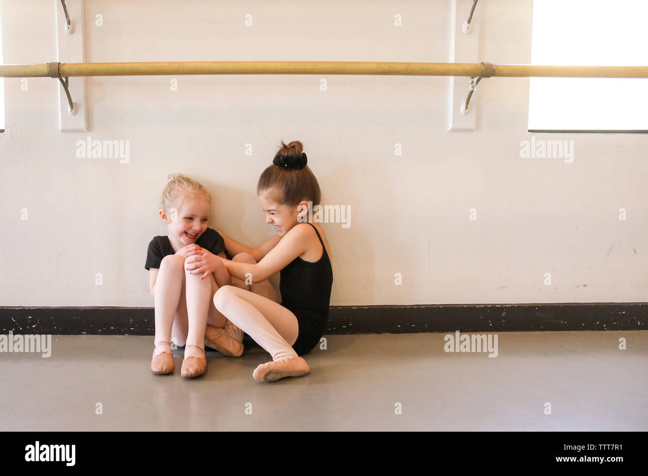 Verspielte Mädchen kitzeln Freund während der Sitzung in Ballett studio Stockfoto