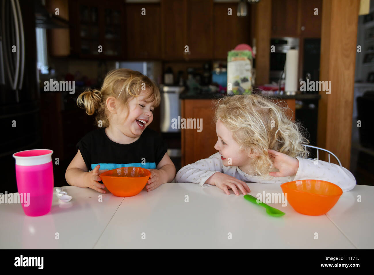Freundliche Schwestern sprechen beim Sitzen am Esstisch Stockfoto