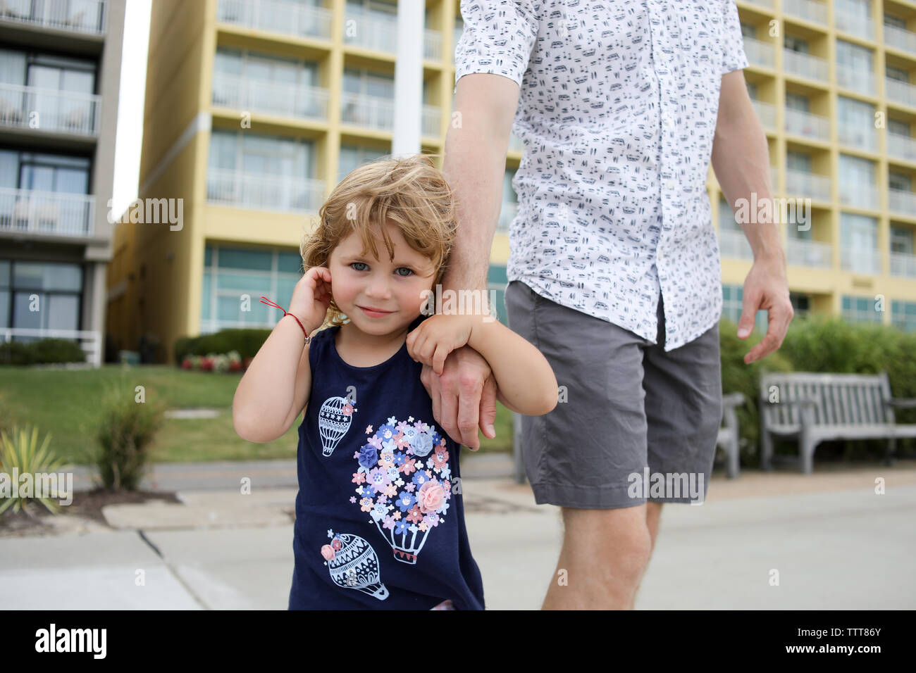 Kleines Mädchen holding Vatis Hand auf der Promenade im Sommer lächelnd Stockfoto