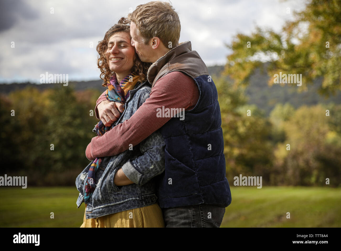 Paar umarmen und küssen schließen oben mit Wind im Feld Stockfoto