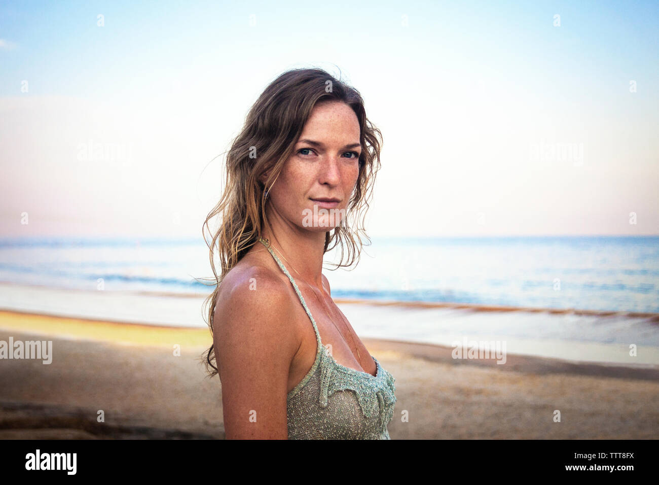 Porträt der schönen Frau am Strand gegen Sky Stockfoto