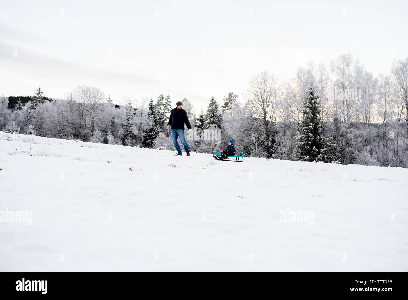 Vater Sohn wandern Rodeln im Schnee weißen wald winter wonderland Stockfoto