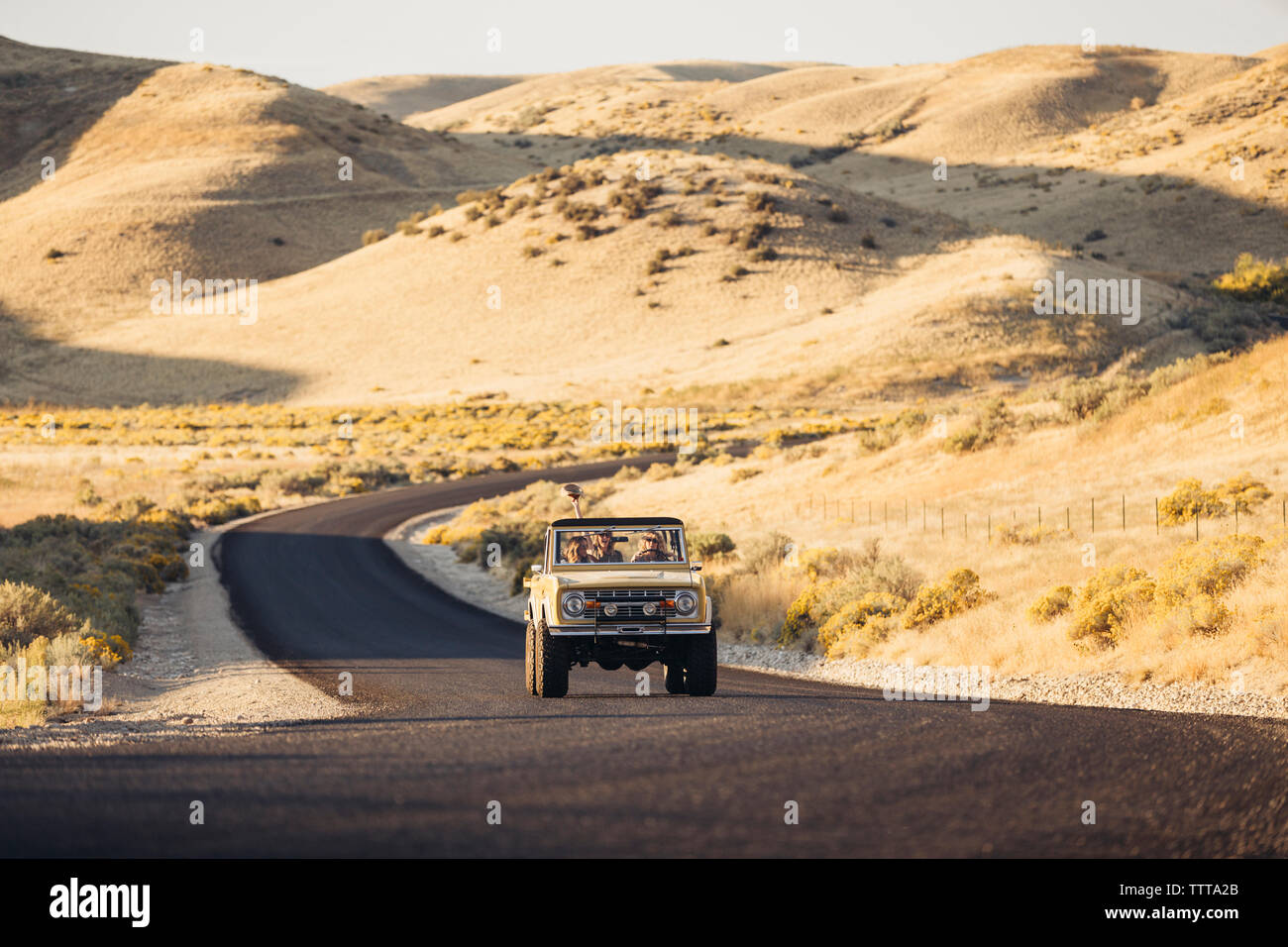 Weibliche Freunde in Geländewagen inmitten von Feld während der Reise Stockfoto